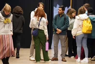 zālē stāv bariņš studentu un runājas