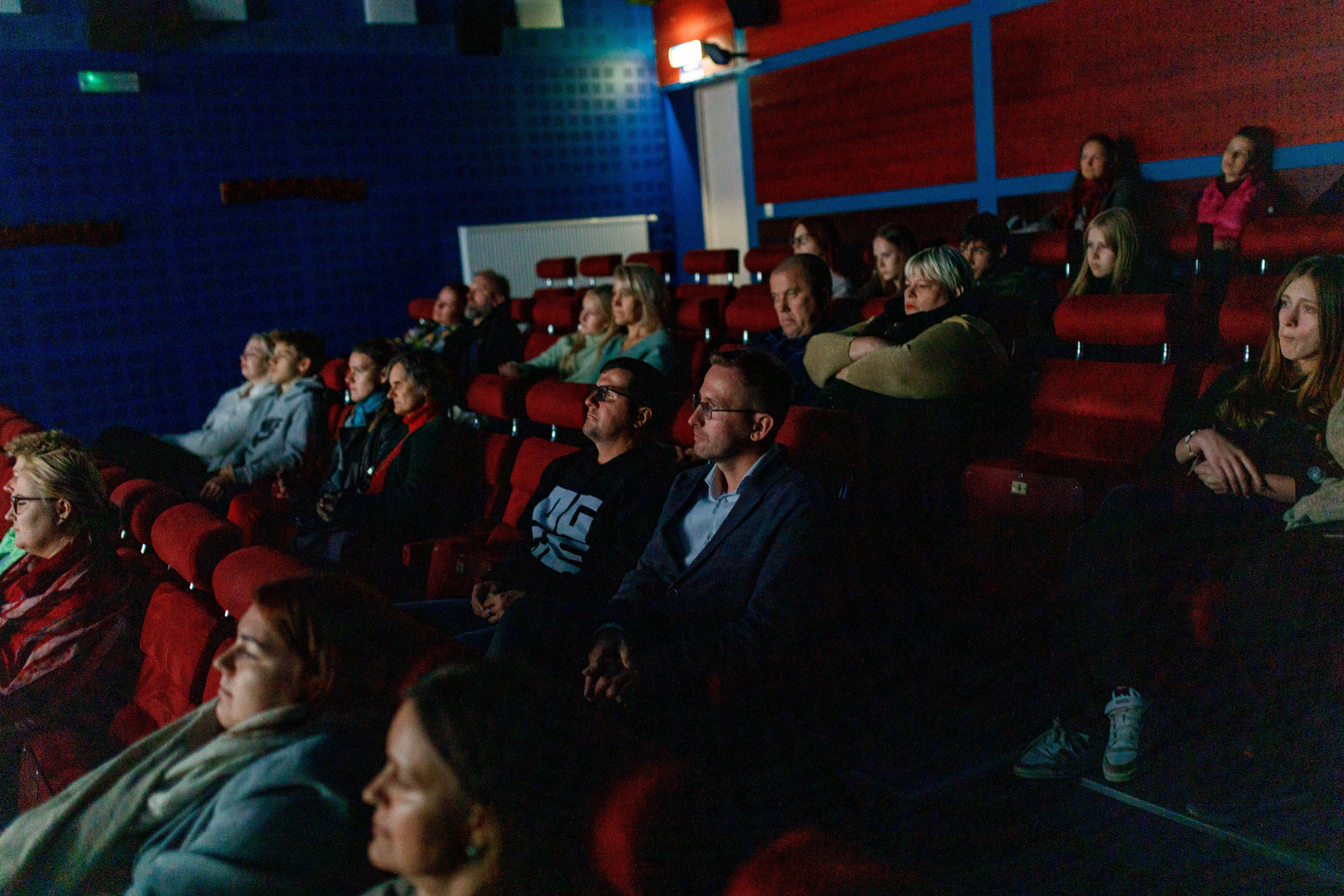 Cilvēki kino zālē skatās filmu